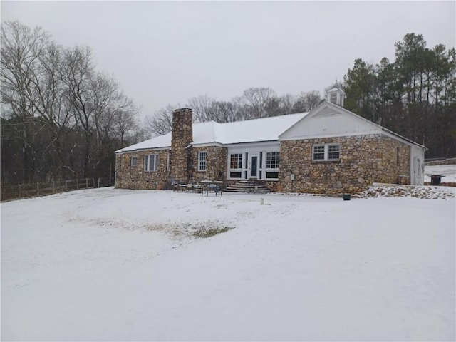 snow covered back of property featuring french doors