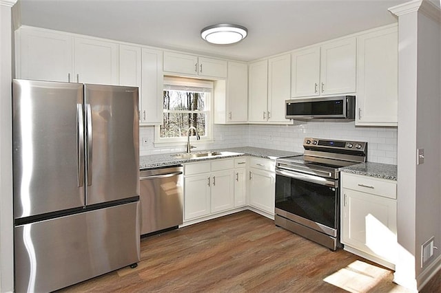 8310 Jensen Trl, Gainesville, GA 30506 - kitchen featuring appliances with stainless steel finishes, a sink, light stone countertops, and white cabinetry
