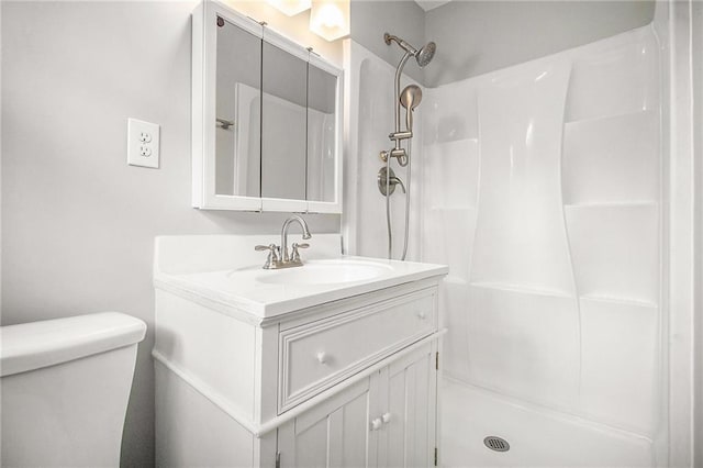 bathroom featuring vanity, toilet, and walk in shower