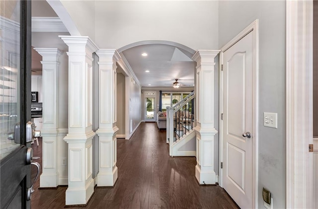 hall with ornamental molding, ornate columns, and dark hardwood / wood-style flooring