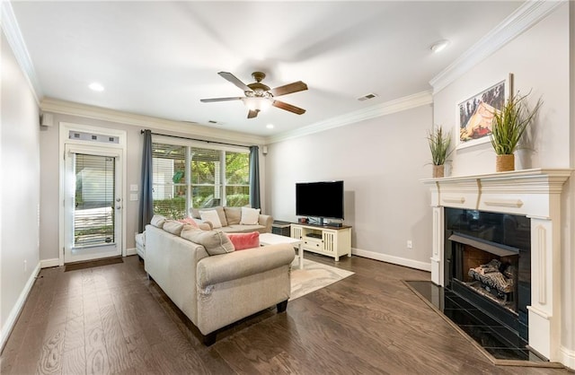 living room with ornamental molding, dark wood-type flooring, a fireplace, and ceiling fan