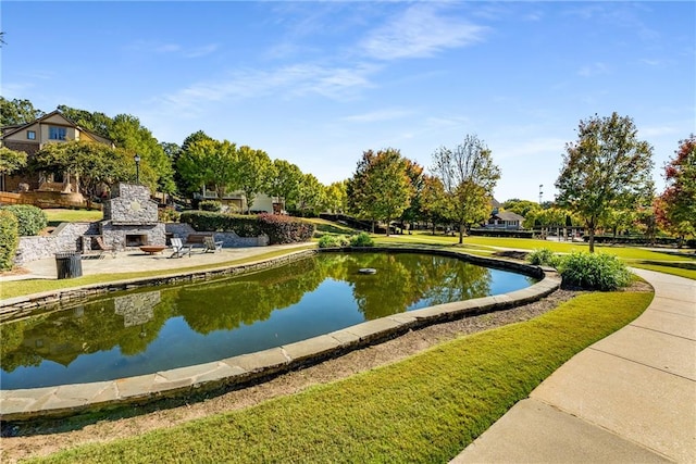 view of property's community featuring a lawn and a water view