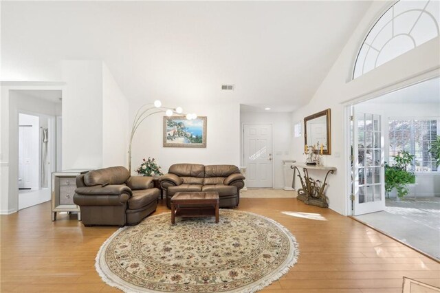 living room with light wood-type flooring and lofted ceiling