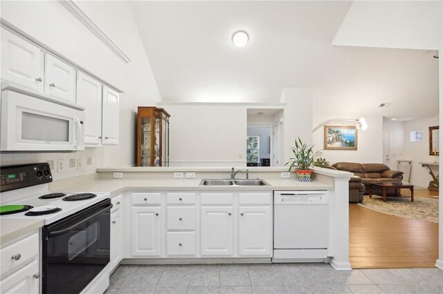 kitchen with kitchen peninsula, white cabinetry, white appliances, and sink