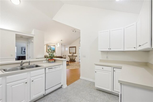 kitchen featuring kitchen peninsula, sink, dishwasher, white cabinetry, and lofted ceiling