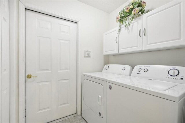 washroom with cabinets and washing machine and dryer