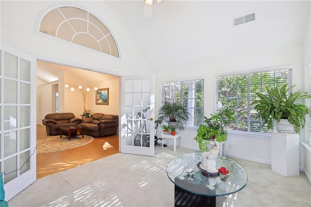 sunroom / solarium with lofted ceiling, a wealth of natural light, and french doors