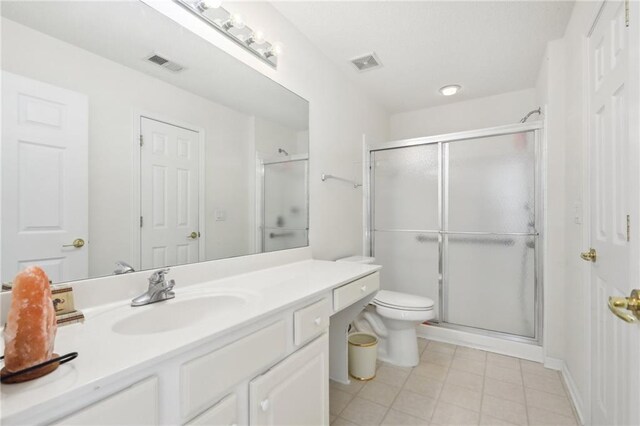 bathroom with vanity, toilet, and a shower with shower door