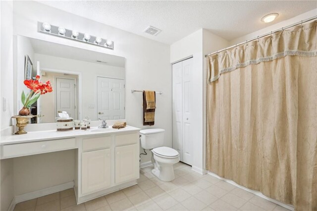 bathroom featuring vanity, a textured ceiling, and toilet