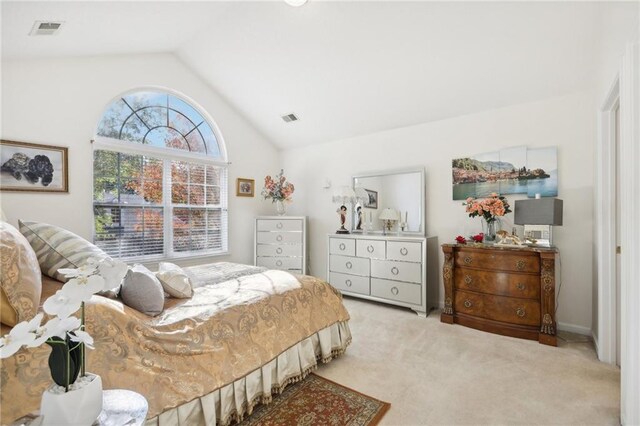 bedroom featuring light colored carpet and vaulted ceiling