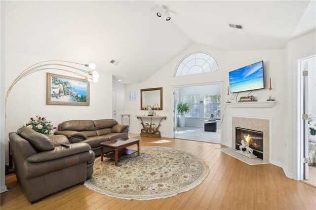 living room with a fireplace, light hardwood / wood-style floors, and lofted ceiling