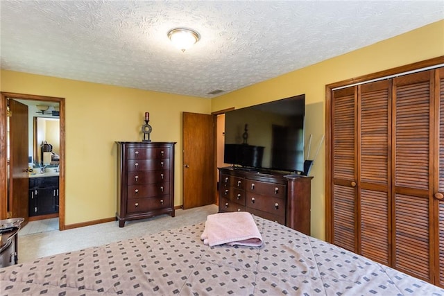 bedroom featuring visible vents, a closet, baseboards, a textured ceiling, and carpet