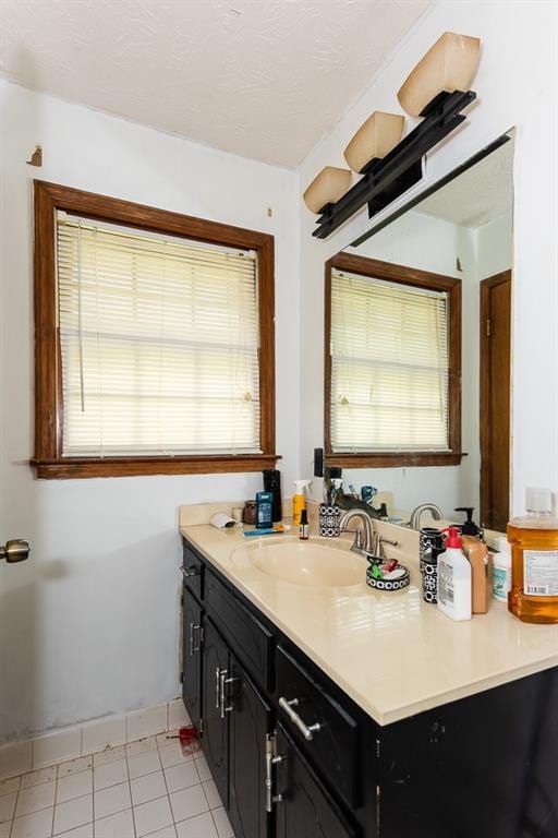 bathroom with vanity, baseboards, and a wealth of natural light