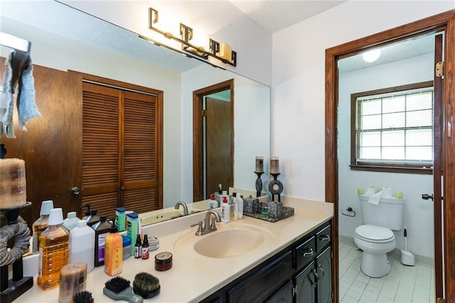 bathroom featuring tile patterned flooring, toilet, and vanity