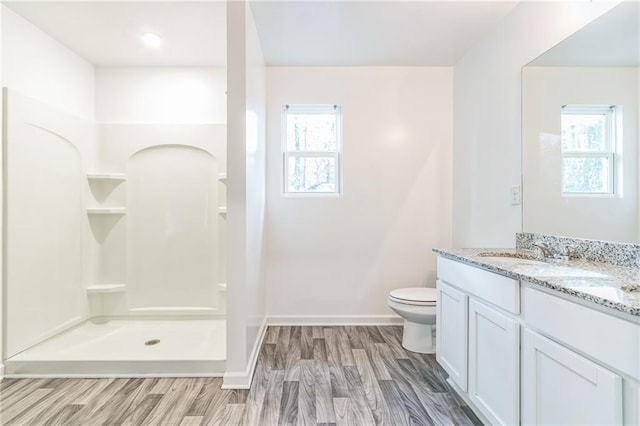 bathroom featuring a shower, vanity, hardwood / wood-style floors, and plenty of natural light