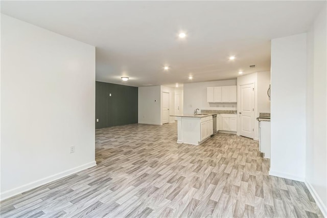 kitchen featuring white cabinets, kitchen peninsula, sink, stainless steel dishwasher, and light hardwood / wood-style flooring