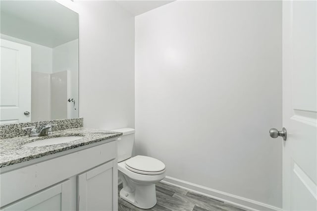 bathroom with wood-type flooring, toilet, and vanity