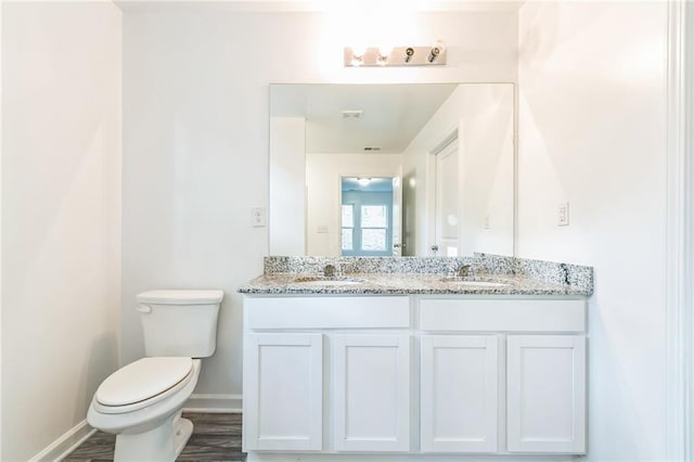 bathroom with hardwood / wood-style floors, vanity, and toilet