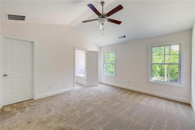 unfurnished bedroom featuring light carpet, lofted ceiling, ceiling fan, and ensuite bathroom