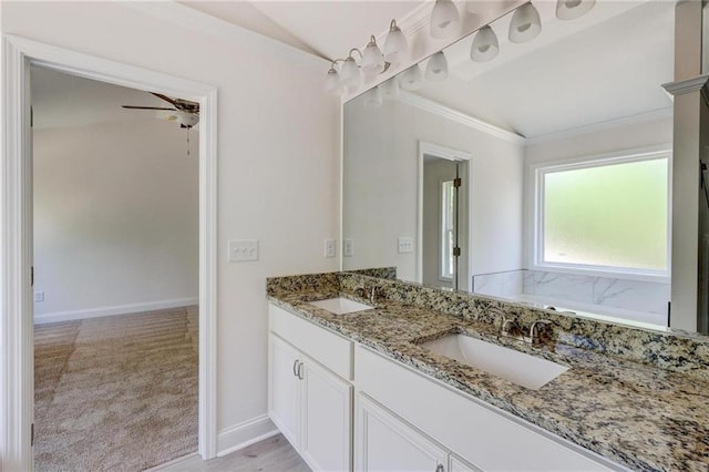 bathroom featuring vanity, crown molding, vaulted ceiling, and a tub