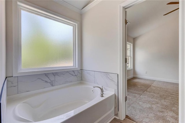 bathroom with crown molding, a bathtub, and ceiling fan