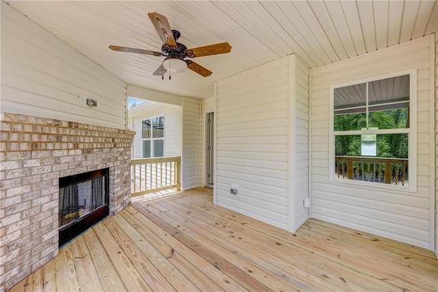 wooden deck featuring an outdoor brick fireplace and ceiling fan