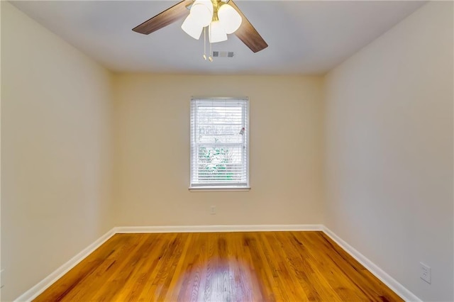 empty room with hardwood / wood-style floors and ceiling fan