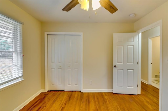 unfurnished bedroom with ceiling fan, a closet, and light hardwood / wood-style flooring