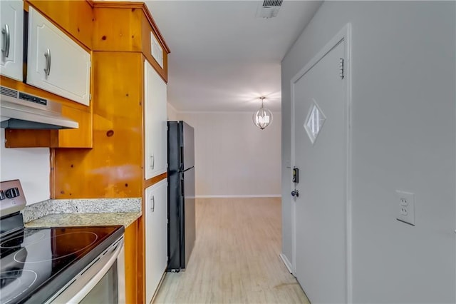 kitchen with black fridge, an inviting chandelier, light hardwood / wood-style floors, and stainless steel range with electric stovetop