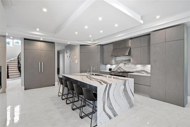 kitchen featuring marble finish floor, wall chimney exhaust hood, modern cabinets, and gray cabinetry