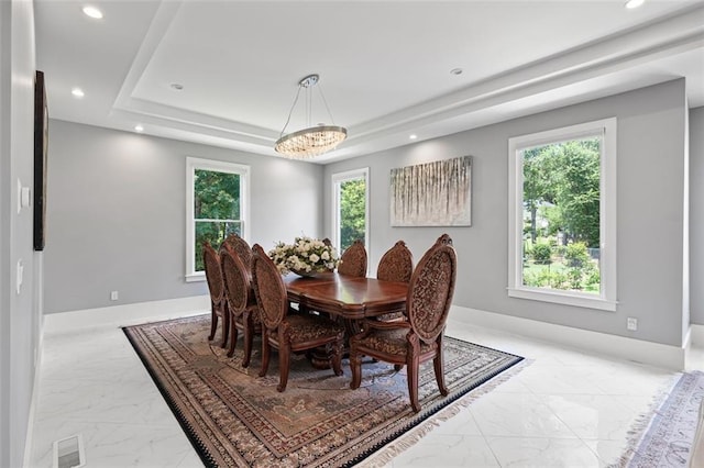 dining space featuring a tray ceiling, marble finish floor, a healthy amount of sunlight, and recessed lighting