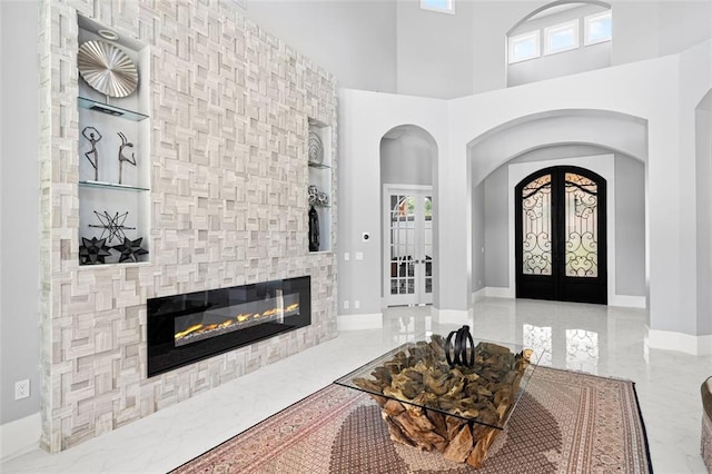 entrance foyer featuring marble finish floor, french doors, and plenty of natural light