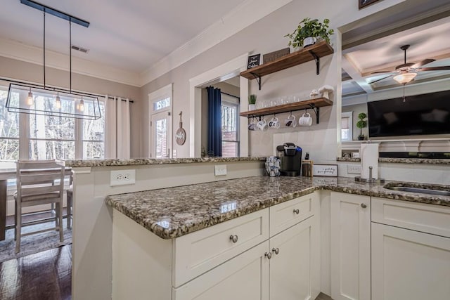 kitchen with dark hardwood / wood-style floors, decorative light fixtures, white cabinetry, dark stone counters, and ornamental molding