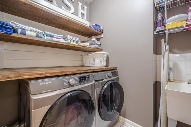 laundry room with tile patterned flooring, sink, and washing machine and clothes dryer