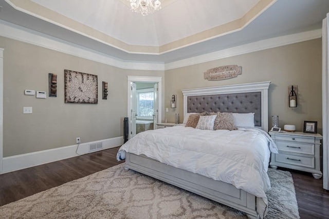 bedroom with dark wood-type flooring, crown molding, a raised ceiling, and a notable chandelier