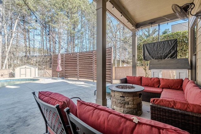 view of patio featuring an outdoor living space with a fire pit, a covered pool, and a storage unit