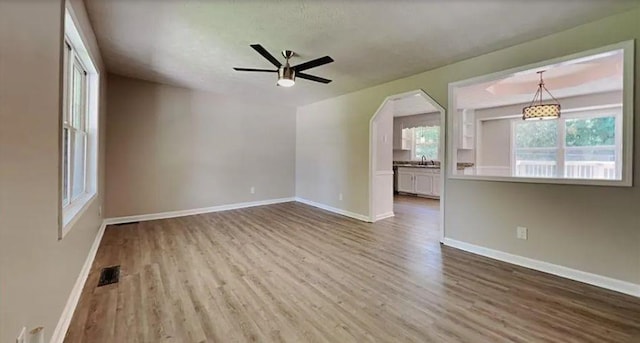 empty room with visible vents, wood finished floors, and baseboards