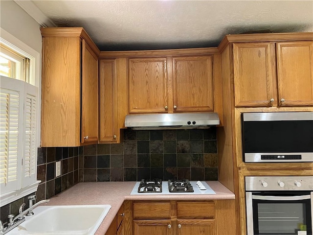 5607 Mountainbrooke Ct, Stone Mountain, GA 30087 - kitchen featuring stainless steel appliances, extractor fan, a sink, and brown cabinets