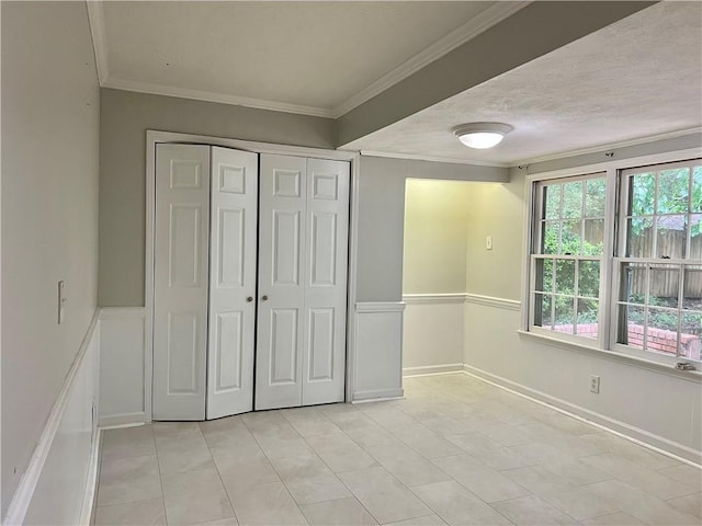 5607 Mountainbrooke Ct, Stone Mountain, GA 30087 - unfurnished bedroom featuring a closet, wainscoting, crown molding, and a textured ceiling