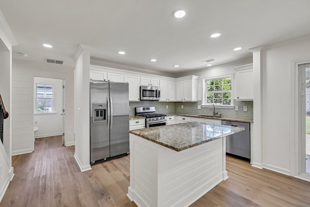 895 Roxfield Ct, Buford, GA 30518 - kitchen featuring stainless steel appliances, a sink, backsplash, white cabinetry, and light stone countertops