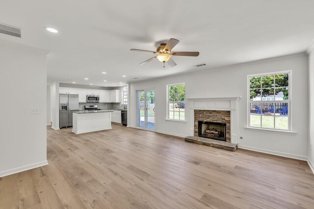 895 Roxfield Ct, Buford, GA 30518 - unfurnished living room featuring a ceiling fan, a stone fireplace, recessed lighting, baseboards, and light wood-style flooring