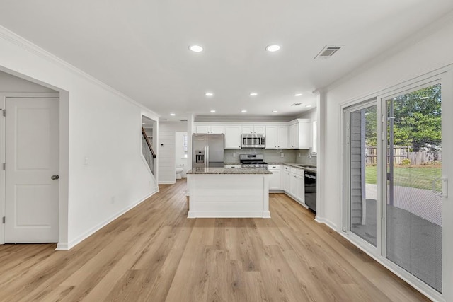 895 Roxfield Ct, Buford, GA 30518 - kitchen with stainless steel appliances, crown molding, baseboards, light wood-type flooring, and white cabinets