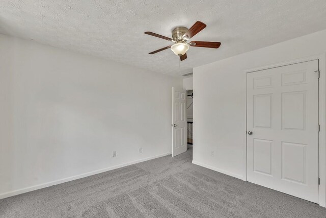895 Roxfield Ct, Buford, GA 30518 - unfurnished bedroom featuring carpet flooring, baseboards, a textured ceiling, and ceiling fan