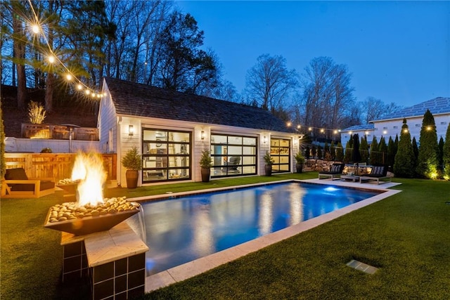 pool with an outbuilding, a storage structure, a yard, a fire pit, and a patio area