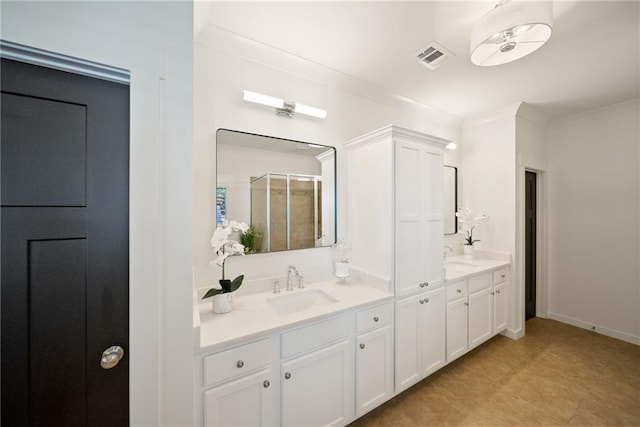 bathroom featuring vanity, visible vents, baseboards, a shower stall, and crown molding