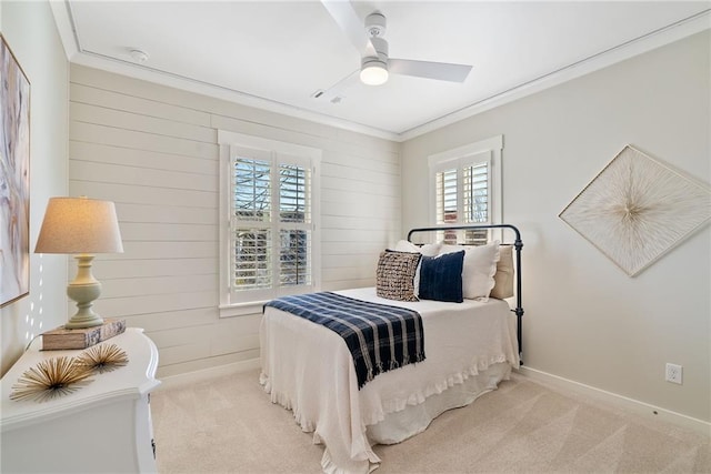 bedroom with baseboards, crown molding, carpet, and a ceiling fan