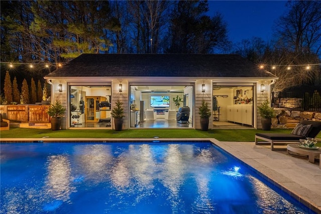 pool at twilight featuring an exterior structure, an outdoor pool, an outdoor structure, and fence