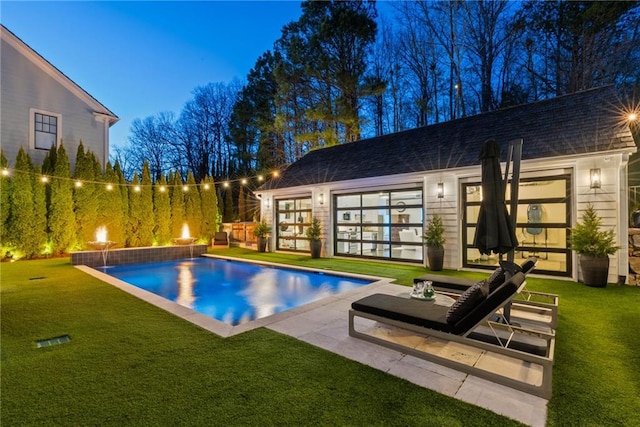 pool featuring a patio area and a lawn