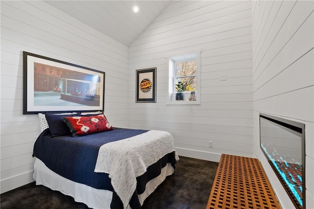 carpeted bedroom featuring baseboards and lofted ceiling