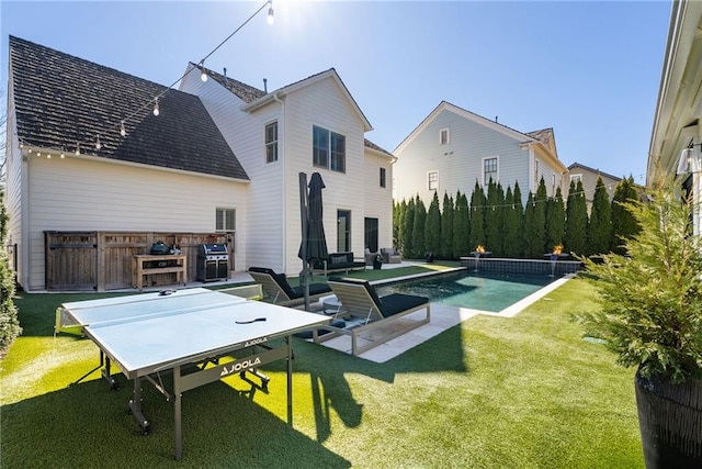 rear view of house with a patio, a yard, fence, and an outdoor living space